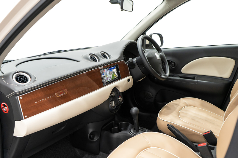 専用色の木目調パネルを採用。助手席側の前方に専用エンブレムを備える