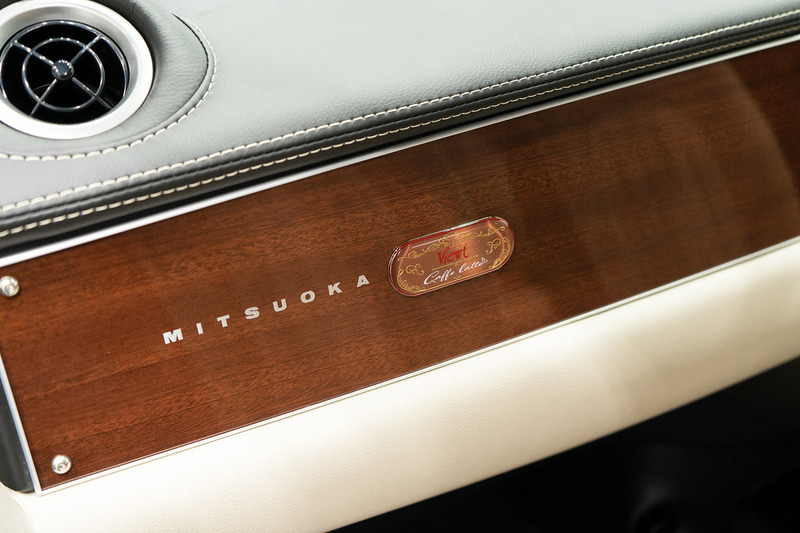 専用色の木目調パネルを採用。助手席側の前方に専用エンブレムを備える