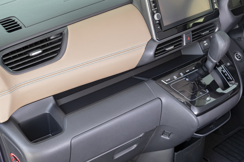 インパネ中段は小物が置けるトレー形状。助手席側にはカップホルダーも備わる