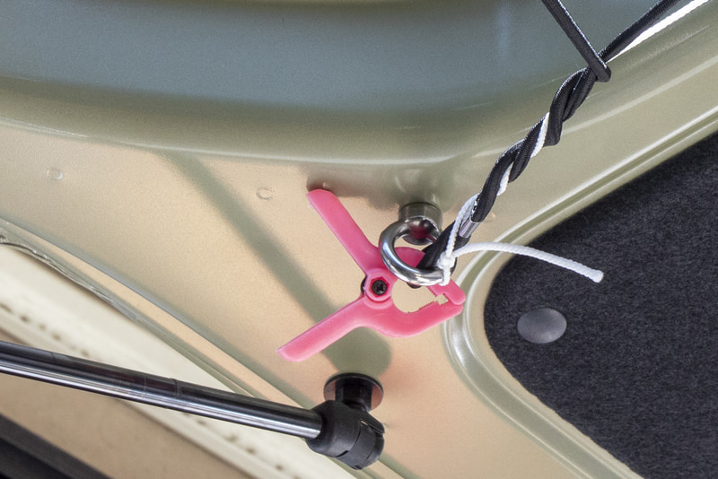 ネットの張り方。リアゲート側はユーティリティナット用のナットホールに装着したリング金具にネットの端を通過させてクリップで固定した