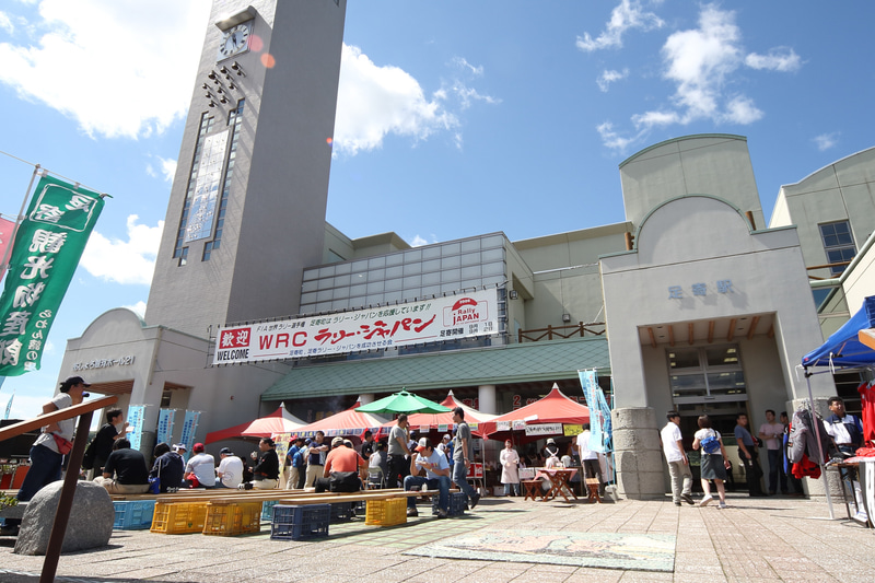 コースサイドにはラリーパークというイベントスペースも設けられ、地元の名物を食べたりしながらのんびりとお祭り気分でラリーカーを待ったりもできます。地元の人にとってはラリーを見に行くというより、ラリーがわが町にやってくるという感じでしょうか（写真は2006年）