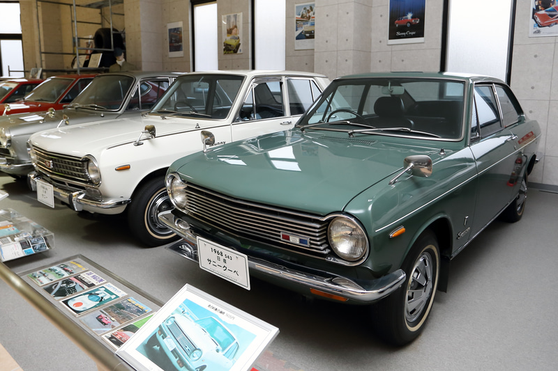 クーペとセダンが揃った日産サニー。手前に並べられた雑誌も壁のポスターも貴重