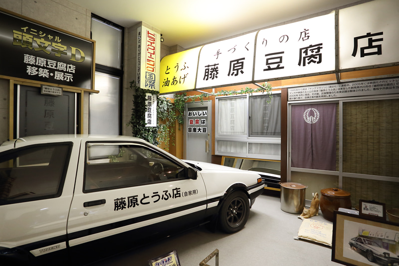 「頭文字（イニシャル）D」の世界が再現されたコーナー。モデルとなった豆腐店の本物の看板を使用している