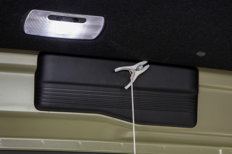 スイッチをレバー式にしたのは操作部をクリップで挟めるようにするため。クリップにひもを付けて垂らしておけば、キャンプ場などでは床に座った姿勢でもロック解除ができるので便利なのだ。座ったり寝ていたりすると立っているときのような後方確認はできないが、キャンプ場などはクルマ周辺の状況が分かっているし、他人がサイト内に入ってくることもないだろうからまあよしとした