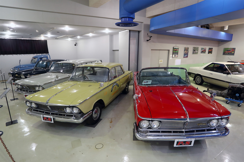 プリンス時代の名車が並ぶコーナー。右の赤いオープン車はさまざまなパレードに使われたという特装メーカー製作の'64グロリア オープン、左は映画「ALWAYS三丁目の夕日'64・3D」の撮影に使われたグロリア タクシー仕様