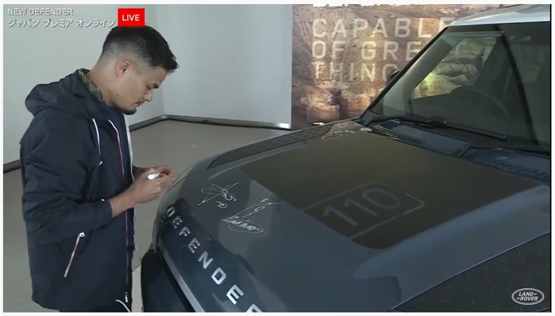 ライブ配信終了後、展示されていた新型ディフェンダーのボンネットにアンバサダーの3人がサインをした