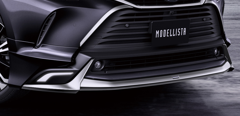 「フロントスポイラー（LED付）」（素地：10万2300円、塗装済：10万7800円）。ロアグリルの構えに沿って縦に伸びる鋭いメッキ加飾と、センターからワイドに広がる造形が融合し、迫力のある存在感を強調。LED付タイプでは、左右にメッキ加飾に呼応した面発光のLEDイルミを配し、輝きあふれるプレミアムスタイルを表現している