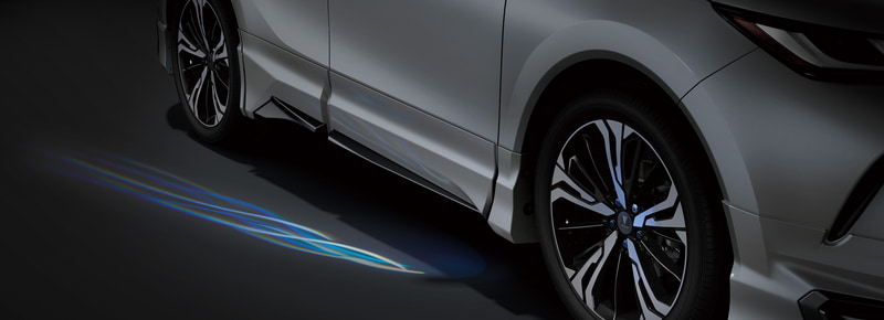 「サイドウェルカムイルミ」（3万5200円）。車両に近づくとドア下側の地面を照らし、ドライバーや同乗者を出迎えるイルミアイテム。鳥の羽をイメージした流麗なイルミデザインが、プレミアム性をさらに高める