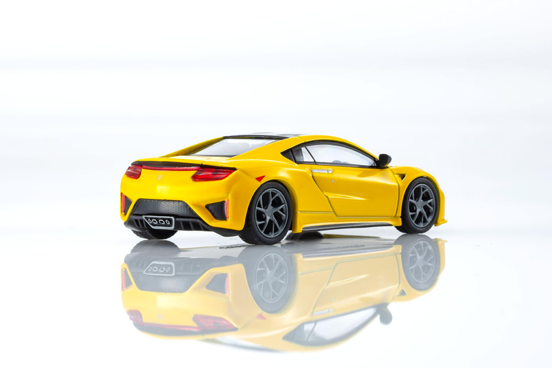 NSXの1/64スケールミニカーは、インディイエローパールIIをベースにしたカラーを採用。ディスプレイ用の台座も付属する