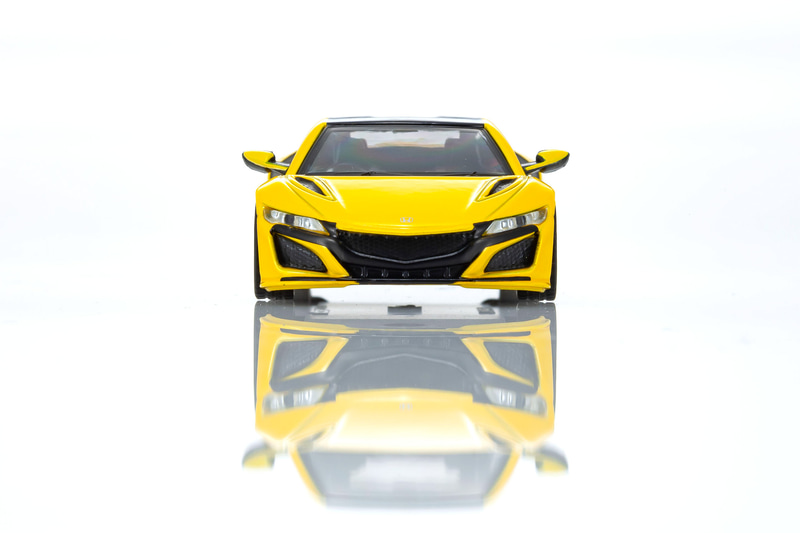 NSXの1/64スケールミニカーは、インディイエローパールIIをベースにしたカラーを採用。ディスプレイ用の台座も付属する