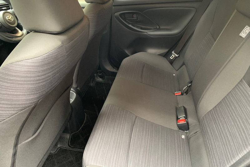 ヤリスのリアシート。昭和生まれの身長169cmのおっさん（オレ）がドラポジを取った時の後席。バックレストと膝の間に拳が1個入ります