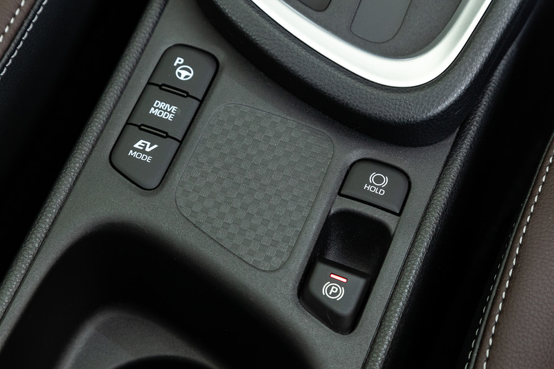 ヤリスクロスではパーキングブレーキが電動式となり、レーダークルーズコントロールが全車速追従機能付に。また、E-Fourは悪路など滑りやすい路面向けの「TRAIL」モード、雪道でのスムーズな発進を行なう「スノー」モードを選択可能なダイヤル（写真右）が付く