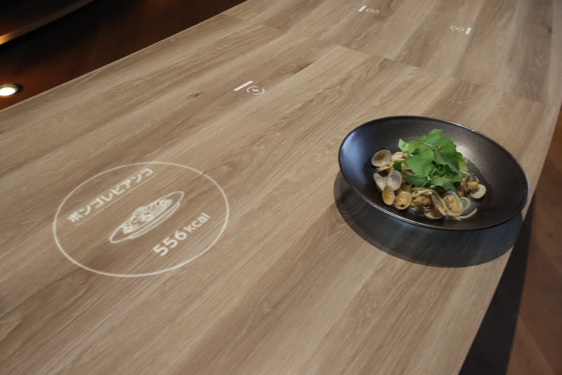料理をテーブルに置くと料理名やカロリーなどがアニメーションでテーブルに映し出される「インタラクティブテーブル」