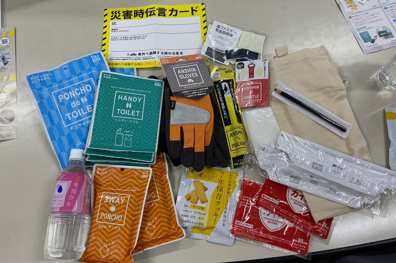 白くて四角い箱の中身は、こんな感じ。いざという時に役立つ13点+コットンバッグと面ファスナーというセットです。なかなか私には思いつかなかったのが、フロントガラスに文字が書きやすく、雨に濡れても消えにくいペン、ダーマトグラフが入っていることです。編集者時代は赤いダーマトを使って校正をしていたんですが、こんなところで再会するとは(笑)。ホイッスルも薄型で軽くて、とても大きな音が出ます。携帯トイレも、どれがいいのか悩んでいたものだったので、よかった! 1点ずつ個別に販売会社の連絡先が書いてあるので、使用したものを補充することもできるようです