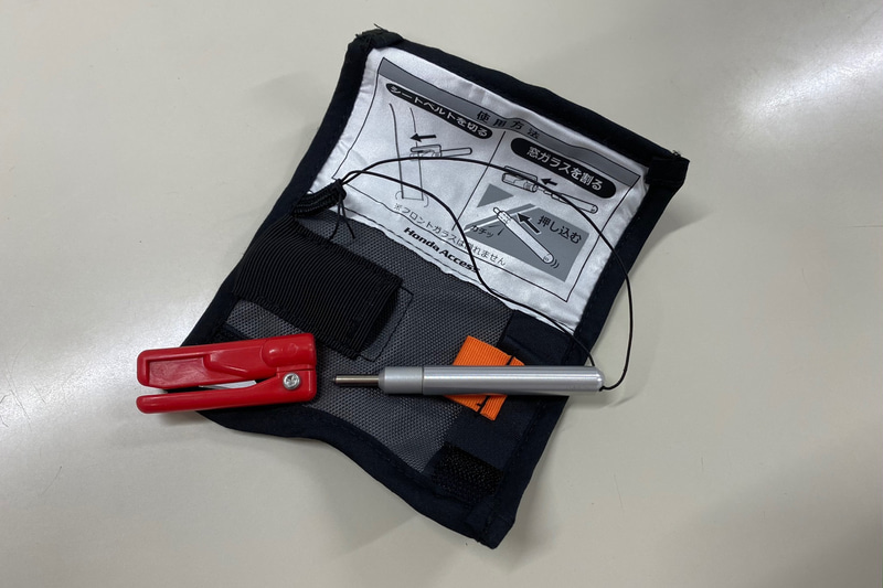 これがとってもコンパクトな緊急脱出・救出用ツール「スマートレスキュー」です。今まで見た中で、いちばん小さくて見た目もいちばんスマート。ホルダーから脱落しないようにストラップもついています。価格は6050円で、こちらもホンダ純正用品なので3年間6万kmの保証付きです。