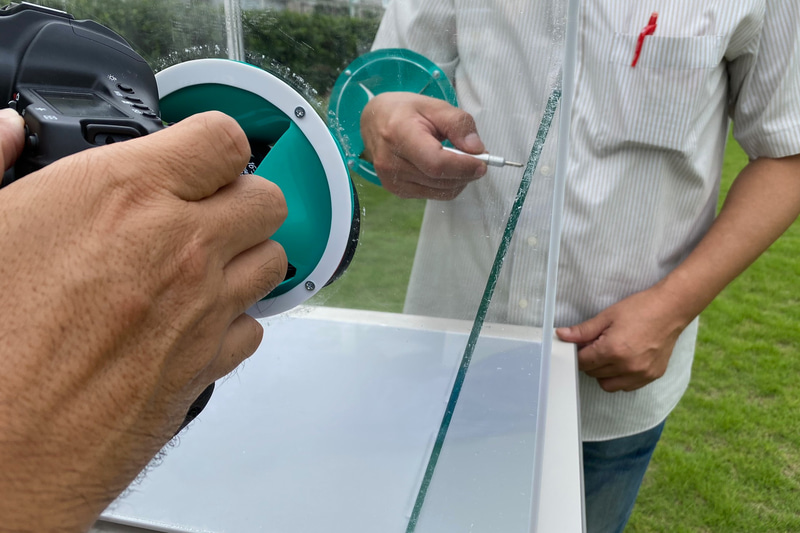 この透明の箱の中にクルマの窓ガラスと同じガラスを入れて、スマートレスキューのツールを試してみました。勢いよく刺すような感じなのかなと思ったら、まず先端をそっとガラスに押し当て、じわじわと力を入れていくと割れるんです。音がとても大きくてビックリしました