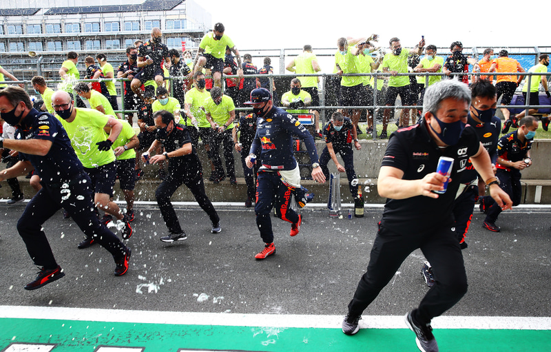 記念撮影後、レッドブルシャワー開始。笑顔で逃げ惑う山本氏と田辺氏　（c）Getty Images / Red Bull Content Pool