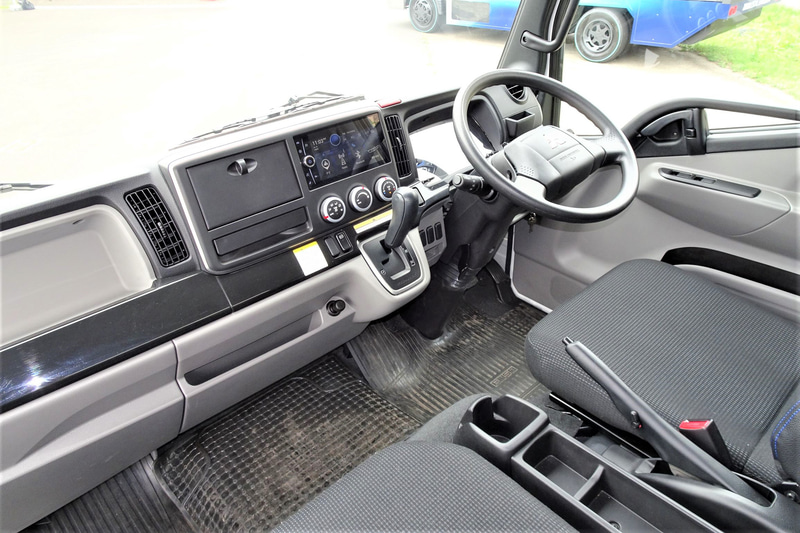 eCanterのキャビン。ディーゼル車をベースにメーター内部の意匠と表示内容をBEV向けに変更。センターディスプレイにはカーナビゲーションやオーディオ情報のほか、車両情報として電池残量、残存走行可能距離、電力消費走行履歴、点検スケジュールなどの表示が可能。Bluetoothによる各種機器との接続もできる。アクセルペダルとブレーキペダルは、ディーゼル車と同じくステアリングシャフト右側に集約されるが、リターンスプリングにはeCanter専用のチューニングが施された