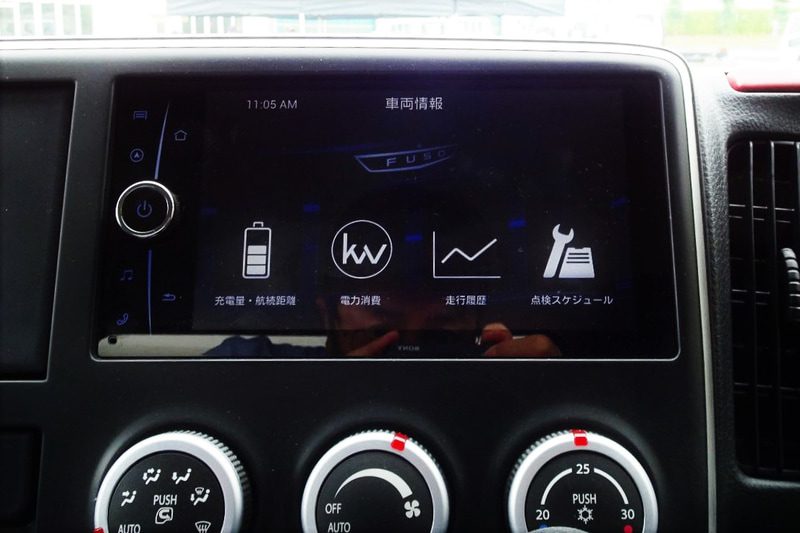 eCanterのキャビン。ディーゼル車をベースにメーター内部の意匠と表示内容をBEV向けに変更。センターディスプレイにはカーナビゲーションやオーディオ情報のほか、車両情報として電池残量、残存走行可能距離、電力消費走行履歴、点検スケジュールなどの表示が可能。Bluetoothによる各種機器との接続もできる。アクセルペダルとブレーキペダルは、ディーゼル車と同じくステアリングシャフト右側に集約されるが、リターンスプリングにはeCanter専用のチューニングが施された