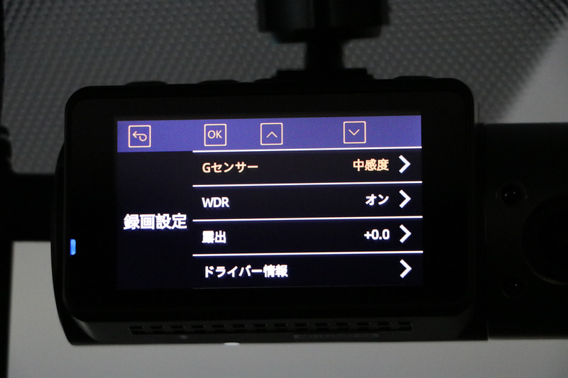 解像度の設定はフロントカメラのみ「WQHD」か「FHD」かを選択可能。リアカメラと車内カメラは「FHD」のみ。ビデオ圧縮形式は一般的な「H264」と高圧縮でより長時間録画できる「H265」が選択可能。ループ録画は「1分」「3分」「5分」から選べる。音声録音は「常時録音」「録音しない」「衝撃があったときだけ録音」の3つのモードから選択可能。Gセンサーは録画を開始するときの衝撃の強さの設定で「小」「中」「大」がある。WDRは逆行やトンネル出入口などの明暗が強い場合の画像補正なので基本的にONのままでOK。露出は「－2.0～＋2.0まで0.5刻みで設定が可能。ドライバー情報は数字とアルファベットを最大9文字登録可能。録画データへ記録もできる。駐車監視は駐車中に衝撃があると録画を開始するモード。スタンプは録画データに「ロゴ」「日付/時刻」「ドライバー情報」「速度」「GPS」といった情報を記録させるか、それぞれ選択できる。リアカメラ設定は後方の映像をモニターに表示させる際に「正像」「鏡像」かを選択できる。ただし録画は正像となる。
