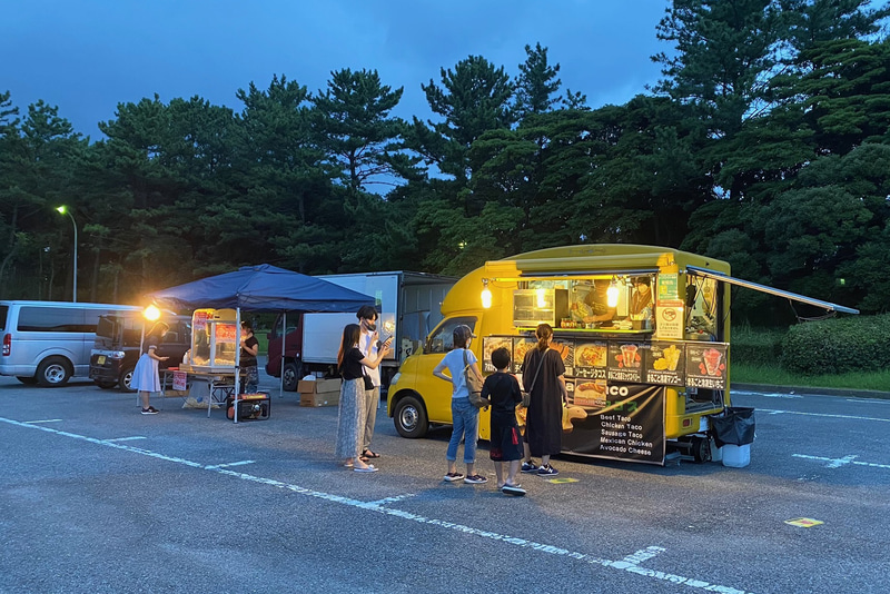 本来は、ドライブスルー形式で楽しめるマルシェ「星空の夜市」というのを楽しみにしていたのですが、残念ながらこの日はお休み。ピザや焼き鳥、ウインナーといったグルメのほか、千葉の農家が丹精込めて育てた農産品の「お楽しみパッケージ」を手に入れることができるそうです。でもこの日は美味しいタコスのキッチンカーとポップコーンを購入することができました。千葉市観光協会では、アフターコロナという新しい価値観による、新しい様式のエンターテインメント空間の創出として、こうした取り組みを行なっているとのことです