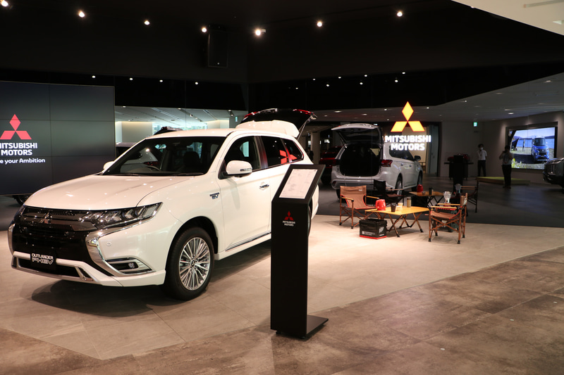 アウトランダーPHEV。プラグインハイブリッドのラゲージスペースにある100Vコンセントから電気を取りポットでお湯を沸かしている演出