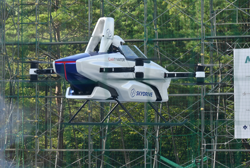 パイロットが右手の人差し指を回してプロペラが回転を開始。すぐにふわりと垂直上昇した。高度は2mをキープしながら、4km/hほどのゆっくりしたスピードでフィールドを一周、元の場所にピタリと着陸した