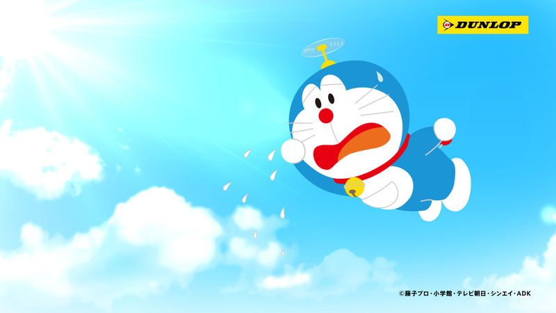 ドラえもんとオールシーズン篇ストーリー：好きな季節にダイヤルをセットすると、まわりの季節をたちまち変えることができるひみつ道具「オールシーズン・バッジ」を使って、暑い夏の日にみんなを涼しくしてあげようと冬に変えるドラえもん。走行中のクルマの周囲には雪が降り始め、運転が少し不安になる。その中でも快適な走りを見せる「ALL SEASON MAXX AS1」。急な雪にも慌てることなく安全かつ安心に走行できる「オールシーズンタイヤ」の特徴を分かりやすく紹介する。（C）藤子プロ・小学館・テレビ朝日・シンエイ・ADK