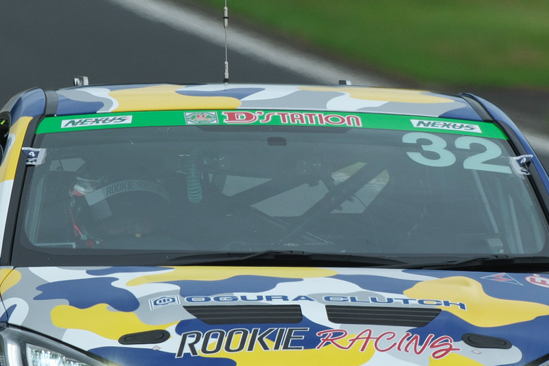 眼鏡の奥に見える鋭い目つきは、どこかで見たような気もする。GRヤリスで走行する謎のドライバーは？　TBNとは誰なのか？