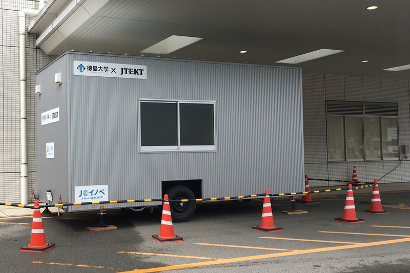 徳島県立中央病院に配備された移動式PCR検査施設の改造機。電源は建屋から取り、水も建屋の水道から引いているが、牽引車に発電機や水タンクを積めば建物がない環境でも稼動できる