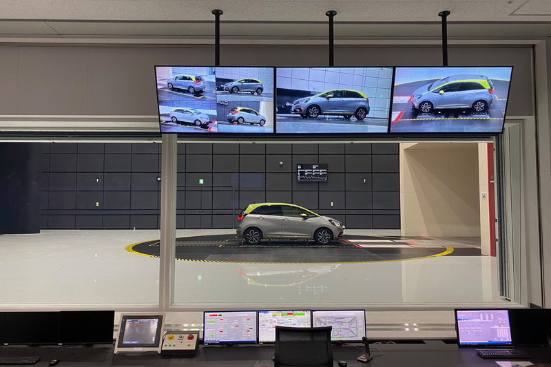 こちらは風洞実験中の光景です。ガラスの外から見ていると、まったく音もなく風もなく、平和（笑）。でも新型フィットの車輪がものすごい勢いで回っているのだけが分かりました