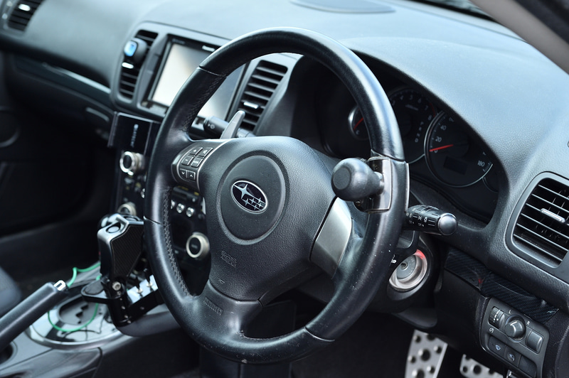 足が動かないオレでも運転ができるよう、手だけで運転可能な手動運転装置を装着している