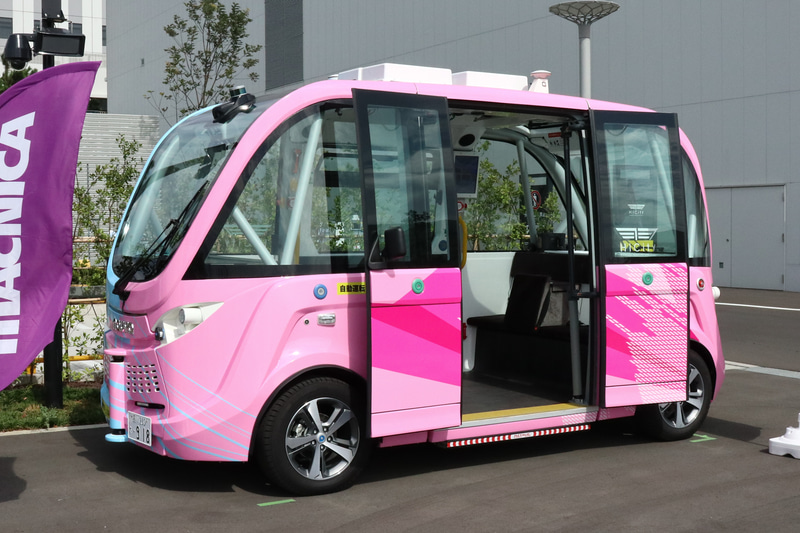 HICityで運行するNAVYA ARMA。ボディは施設コンセプトである先端産業の青、文化産業の赤紫の融合をイメージしてデザイン。左右で色が異なり、ドア側が赤紫となる