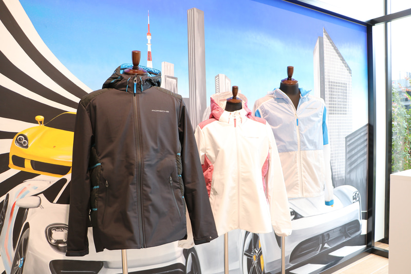 耐水圧3000mm、透湿性3000g/m<sup>2</sup>/24時間のジャケット。フード、ショルダー、背面、およびサイドパネルはパッド入り。胸に光を反射するポルシェロゴ入り。価格5万2580円