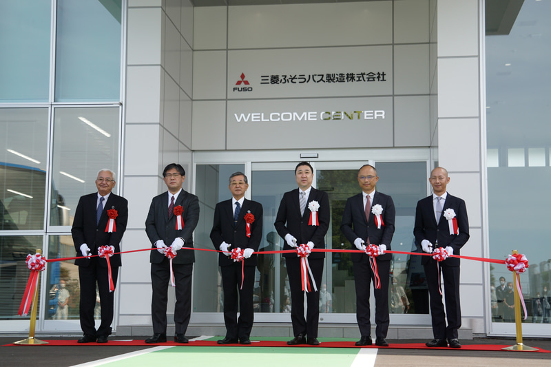 「ウェルカムセンター」落成式典テープカットの様子。写真は左より、沖縄ふそう自動車株式会社 代表取締役社長 輿那覇明氏、沖縄バス株式会社 常務取締役 新川幹夫氏、沖縄バス株式会社 代表取締役社長 中山良邦氏、三菱ふそうバス製造株式会社 取締役会長兼三菱ふそうトラック・バス株式会社 バス 販売本部長 高羅克人氏、三菱ふそうバス製造株式会社 取締役社長 藤岡佳一郎氏、三菱ふそうバス製造株式会社 取締役 CFO 日出嶋達郎氏