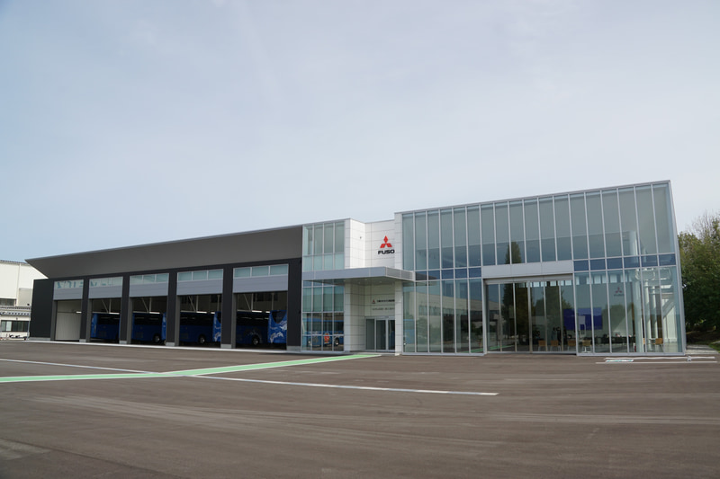 三菱ふそうバス製造の本社・工場敷地内に新設された「ウェルカムセンター」。5つの検収レーンに加えてバスを展示するショールームを併設した