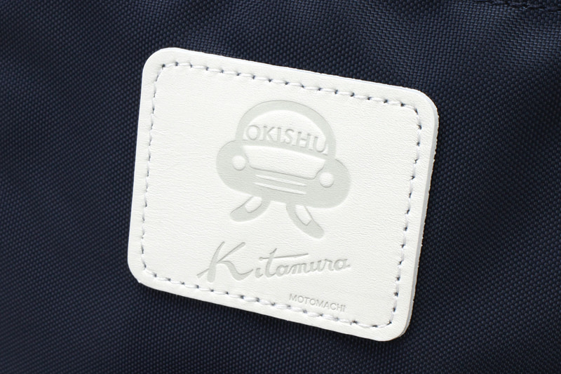 シューズケースで私の一番のお気に入りポイントは、「＃置きシュー」のロゴマークとキタムラのダブルネームタグ！　作成中には、「もっと目立つように外側につけましょうか？」とキタムラの皆さんにもおっしゃっていただいたのですが、やっぱり見た目はキタムラらしい上品さでまとめてほしいなと思い、内側にさりげなくつけていただきました。でも、それだけでも私にとっては奇跡のダブルネームです！