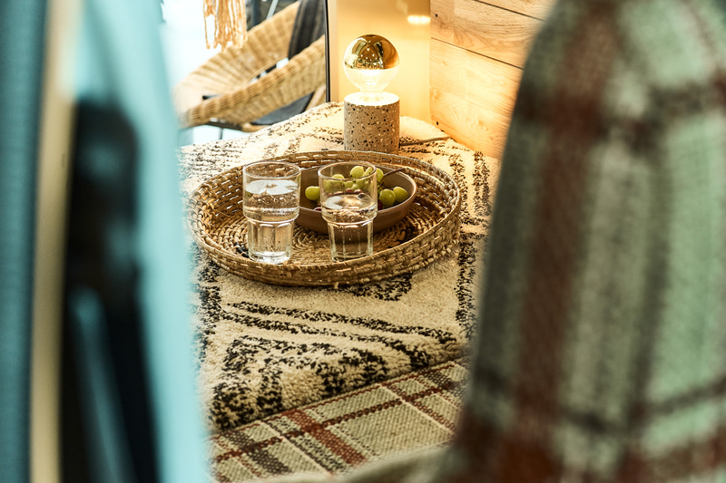 「ACME Furniture」のオリジナルファブリック「AC-08」を用いたシートカバー。1980年代のテキサス州を舞台にした映画の作中に登場するソファーの張地をイメージして作られたファブリックは、絶妙に擦れた配色の大判チェックがACME Furniture らしさを色濃く表現する。今回のモデルではこのファブリックが漂わせるノスタルジックな趣とVANLIFE発祥の地であるアメリカの空気感に思いを馳せ採用。共地のクッションも付属するので、ソファをそのまま車内に持ち込んだような心地よさと洒脱さを実現する