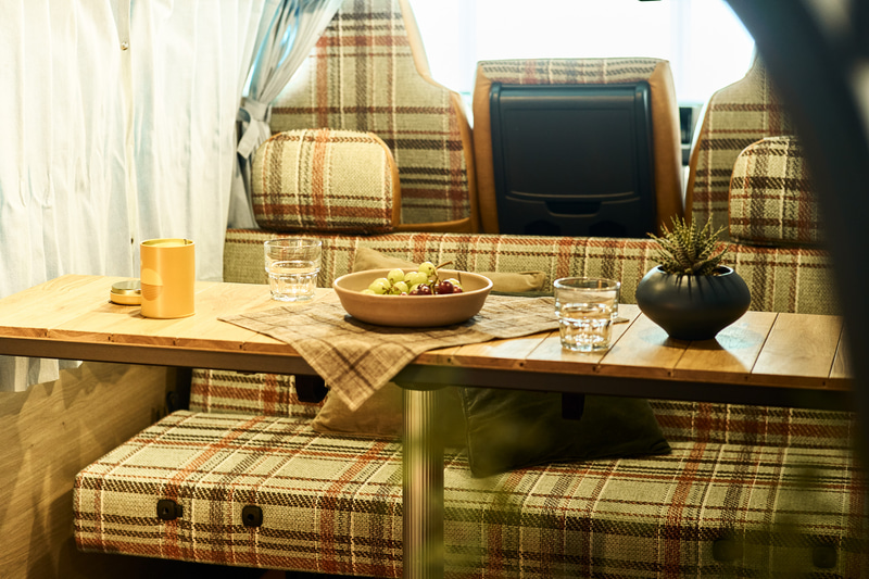 「ACME Furniture」のオリジナルファブリック「AC-08」を用いたシートカバー。1980年代のテキサス州を舞台にした映画の作中に登場するソファーの張地をイメージして作られたファブリックは、絶妙に擦れた配色の大判チェックがACME Furniture らしさを色濃く表現する。今回のモデルではこのファブリックが漂わせるノスタルジックな趣とVANLIFE発祥の地であるアメリカの空気感に思いを馳せ採用。共地のクッションも付属するので、ソファをそのまま車内に持ち込んだような心地よさと洒脱さを実現する