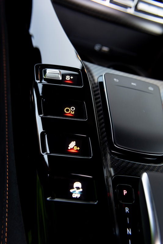 V字型のセンターコンソールにあるカラーディスプレイボタンは、ドライブモード、トランスミッションロジック、サスペンション、ESP（エレクトロニック・スタビリティ・プログラム＝横滑り防止機能）、エキゾーストシステム、リアエアロフォイルフラップ、スタート/ストップといった機能が備わる