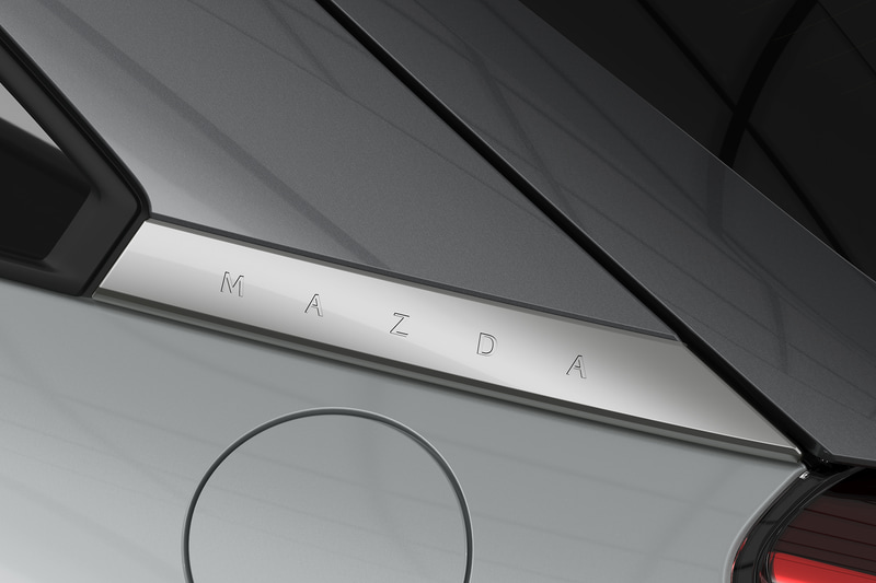 フレームドトップでは、AピラーからDピラーのキャブサイドの一部とリアゲートサイド部分をメタリックカラーとすることで、キャビンのスピード感と一体感あるリアエンドを強調。Dピラーとボディの境目にサテンクロームメッキのプレートを配置し、ブランドネーム「MAZDA」を刻印する