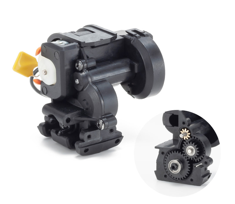 カバ―で覆われたミニッツ4×4のメインギヤユニット。急勾配に対応する超ローギヤから、平坦な道をスムーズに走行するハイスピードギヤまで、付属の6つのピニオンギヤで変更できる。モーターの外側に装着する専用スペーサーで、難しいバックラッシュ調整が不要