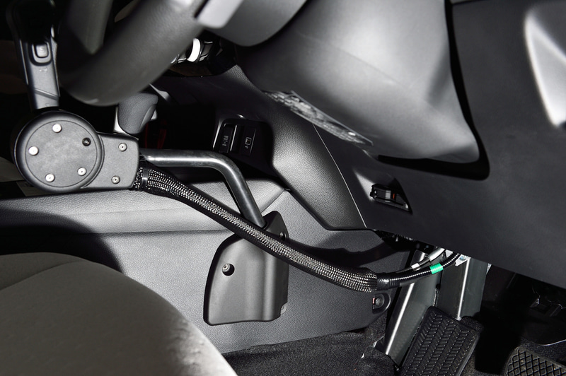 センターコンソールとの接続部分にはカバーが付き仕上がりも美しい。前方に伸びている黒いコードの中にはワイヤーが仕込まれており、このワイヤー経由でアクセルとブレーキを操作する