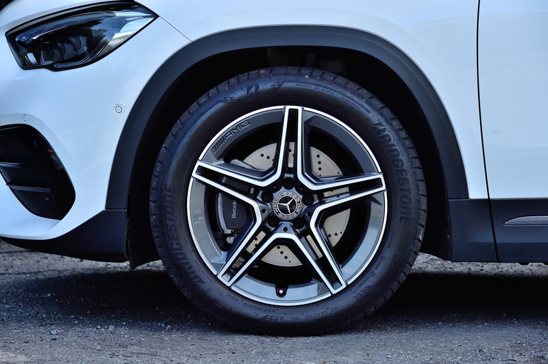 フロントフェンダーからリアフェンダー、リアのコンビネーションランプへと回り込む面の張りが強調された力強いショルダー部、クーペのようにリアにむかってなだらかに下降していくルーフライン、上下方向にスリムなサイドウィンドウを採用。試乗車はオプションの「AMGライン」を装備し、足下は5本ツインスポークの19インチホイールにブリヂストン「TURANZA T005」（235/50R19）の組み合わせ