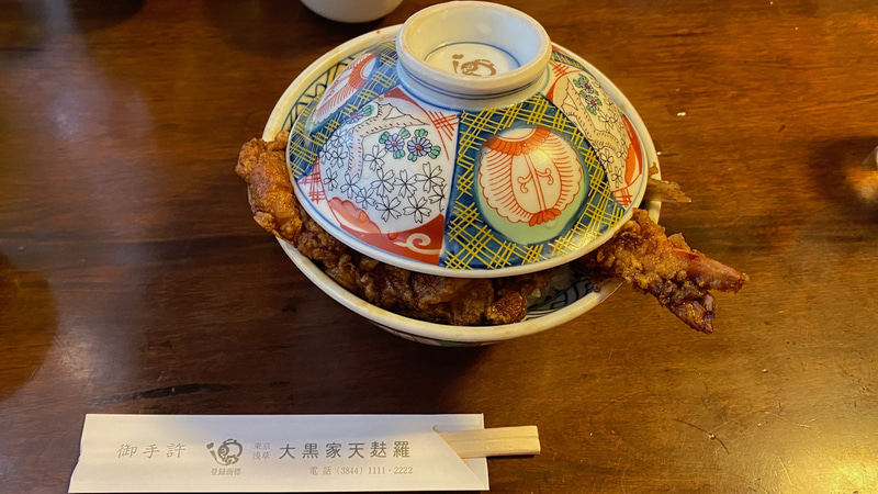 創業明治20年という、浅草名物、大黒屋の天丼がこちら。江戸前の特徴として、ごま油100％で揚げたキツネ色と、丼ぶりに蓋がついて出てくるので、衣がしっとりと柔らかいことでしょうか。創業以来ずっと守ってきたという、甘辛く濃厚なタレがよくご飯にも染み込んで、見た目にも食欲をそそります。色は濃いですがお味の濃さはちょうどよい加減。噛むほどになんだかホッとする、優しい天丼のファンになりました