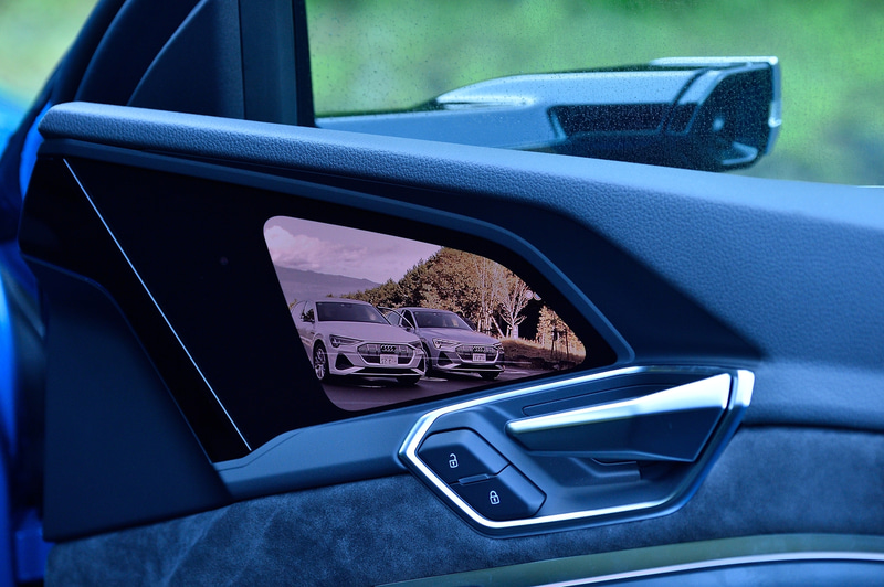 Aピラーに取り付けられたカメラの映像を、車内のOLEDタッチスクリーンに表示するバーチャルエクステリアミラーをアウディとして初採用。夜間でも高い視認性を確保するとともに、空力性能を考慮したデザインにより、航続距離にも寄与している。カメラの角度は車内のタッチスクリーンから操作可能