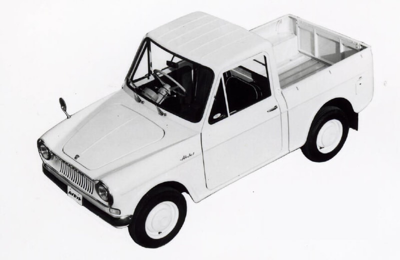 初代 ハイゼット 1960年11月：高度経済成長期の真っただ中、当時大ヒットしていた軽三輪自動車「ミゼット」に続き、ダイハツ初の軽四輪自動車（360㏄）として発売。当時の軽四輪自動車のイメージを刷新する斬新なデザインで、積載性だけでなく、居住性にもこだわっていた。1961年にはボンネットバンタイプも発売し、ビジネスとレジャーを結ぶニューファミリーカーとして、1家に1台のマイカー時代を支えた