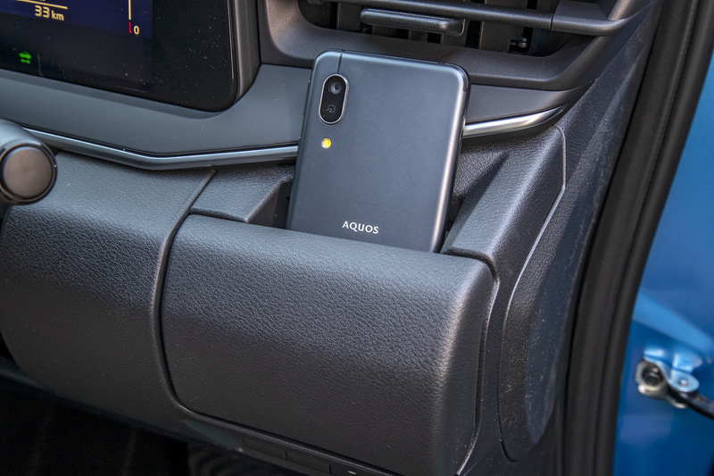 運転席側のカップホルダーは紙パックにも対応。収納時はスマホを置くことができるポケット形状になる