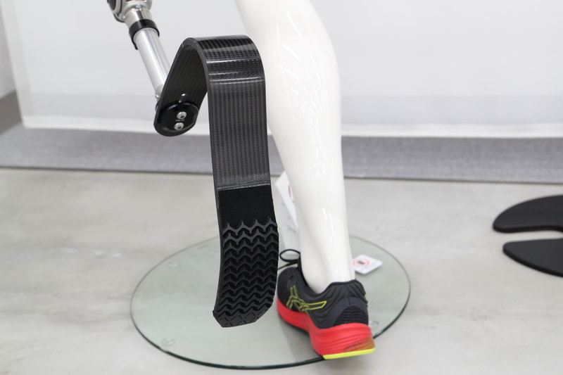 障がい者、ジュニア、シニアをはじめとする全ての人を支える活動「AHL」に関するコーナー。パネルとともにゴム人工筋肉や競技用義足などが展示されている