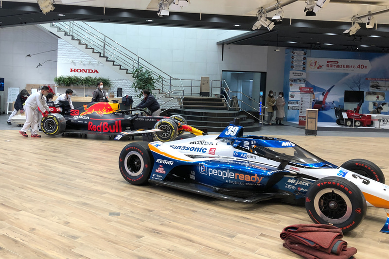 ウエルカムプラザ青山内に運び込まれるレッドブルのRB16。手前はインディ500優勝車